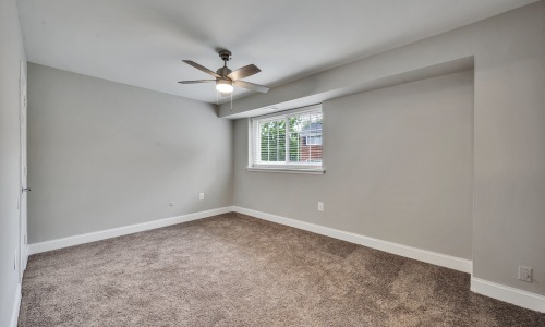 a bedroom with carpet and a fan